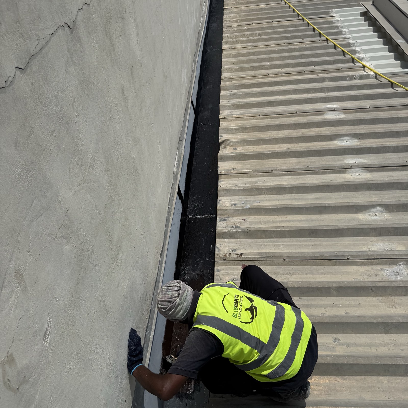 Hand treatment of the parapet junction on the warehouse roof