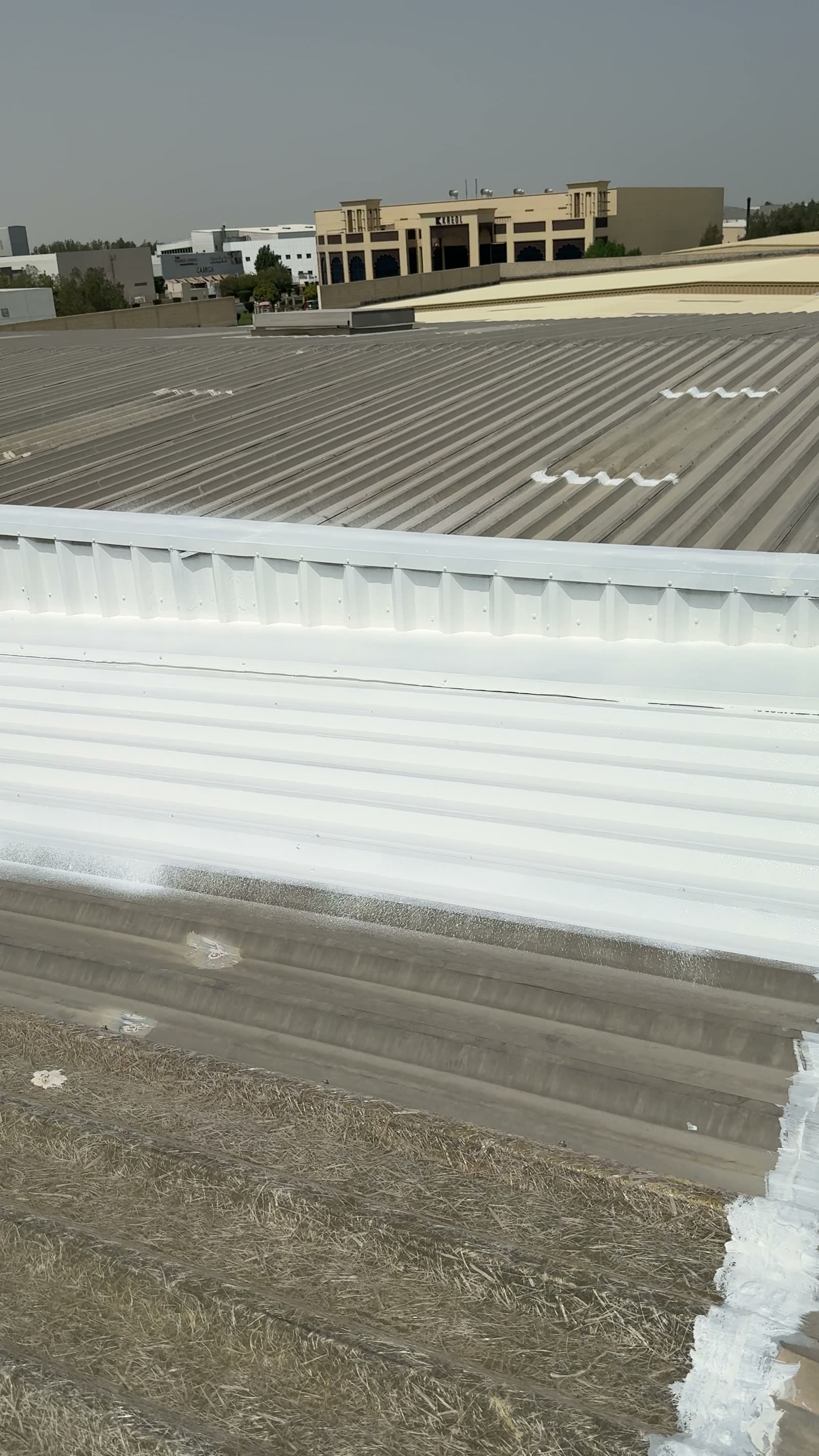 Finished white reflective coating across the warehouse roof in Dubai Investment Park 2